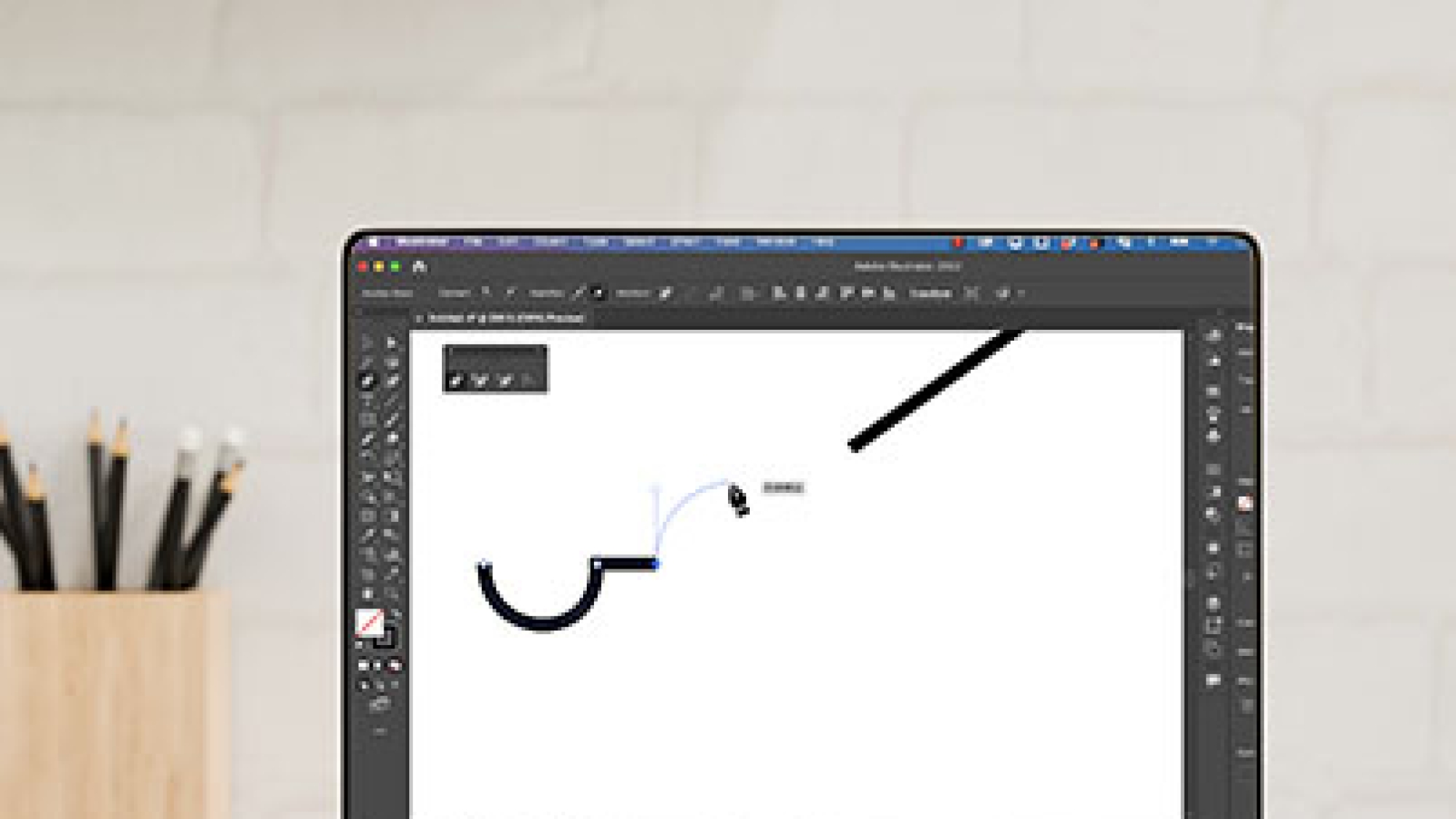 Image of Illustrator with pen tool drawing on laptop