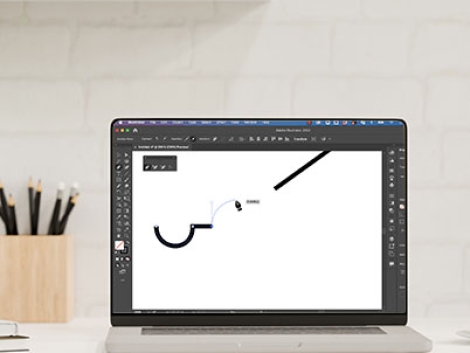 Image of Illustrator with pen tool drawing on laptop